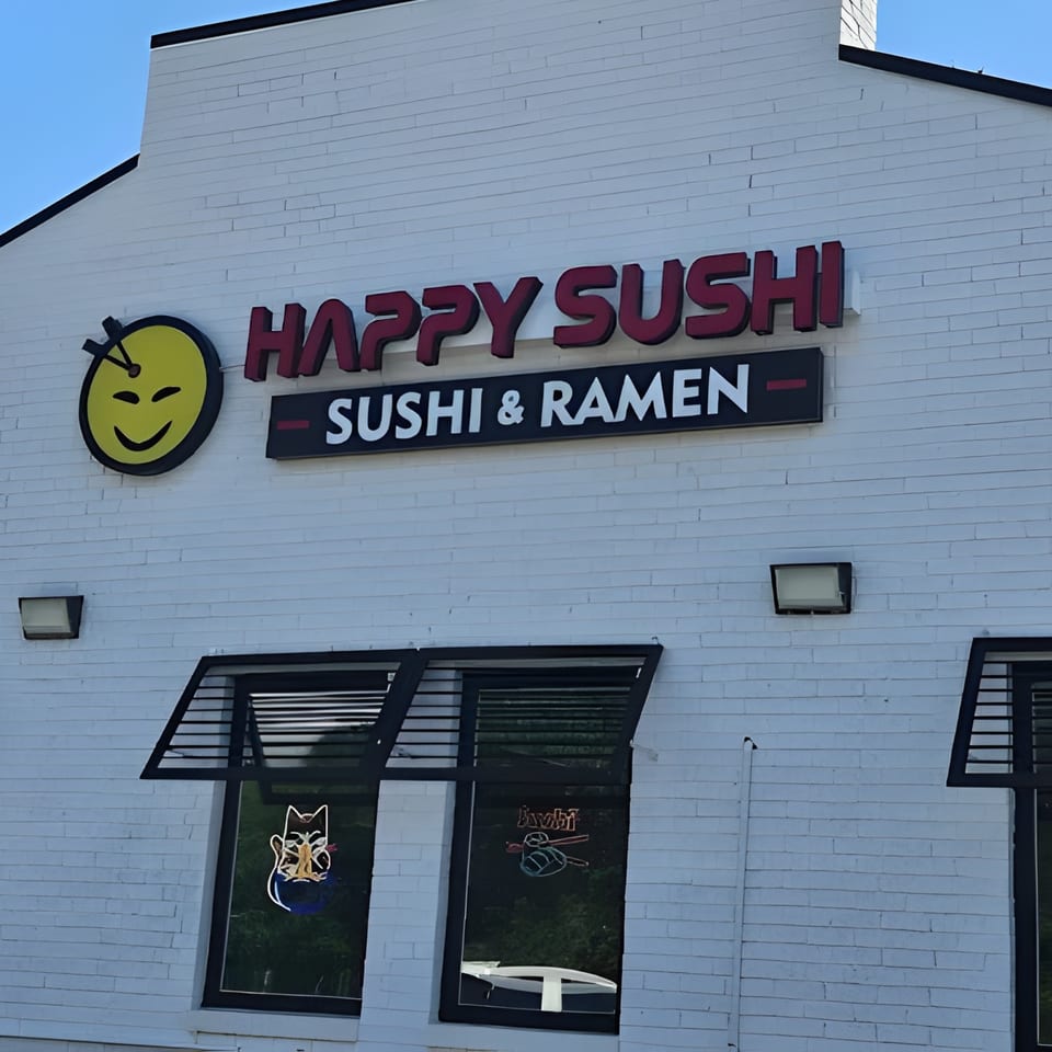 Happy Sushi restaurant exterior with a yellow smiley face logo and "Sushi & Ramen" sign.